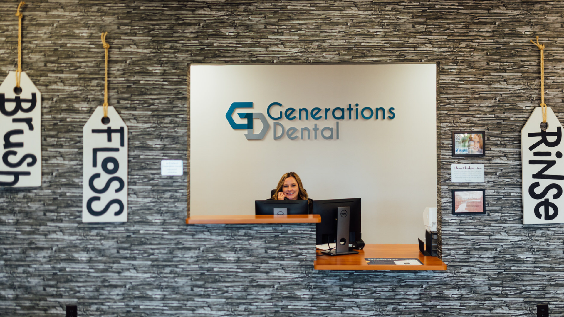 Front desk team member answering the phone to help patient at Generations Dental in Poplar Grove, IL