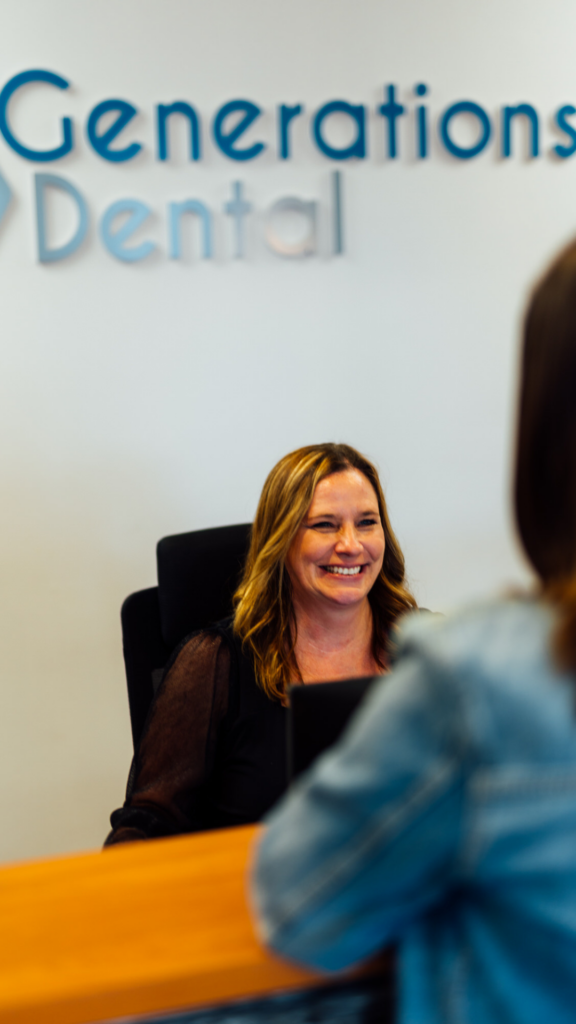 Front desk team member smiling at patient, Generations Dental in Poplar Grove, IL
